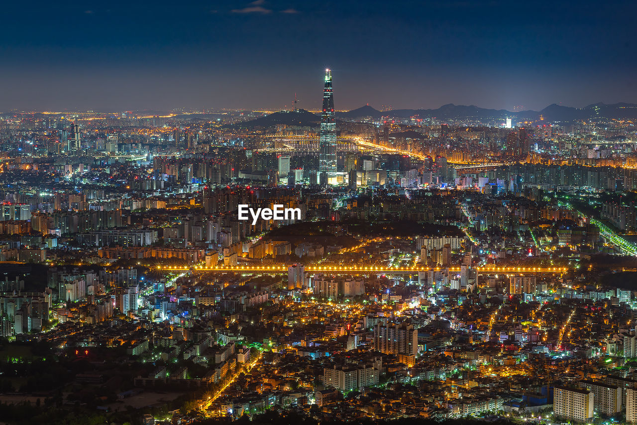 HIGH ANGLE VIEW OF ILLUMINATED CITY AT NIGHT