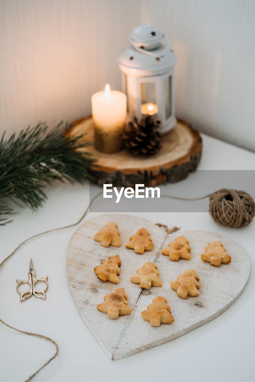 Cozy christmas mood. craft homemade cookies christmas tree shape in wooden tray on table with fir
