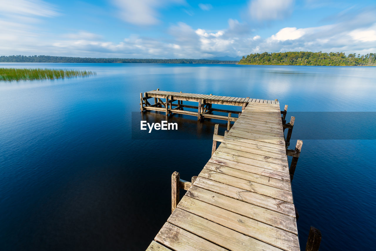 PIER OVER LAKE AGAINST BLUE SKY