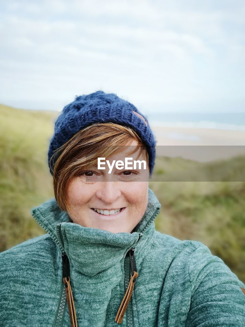 Portrait of smiling woman against sky