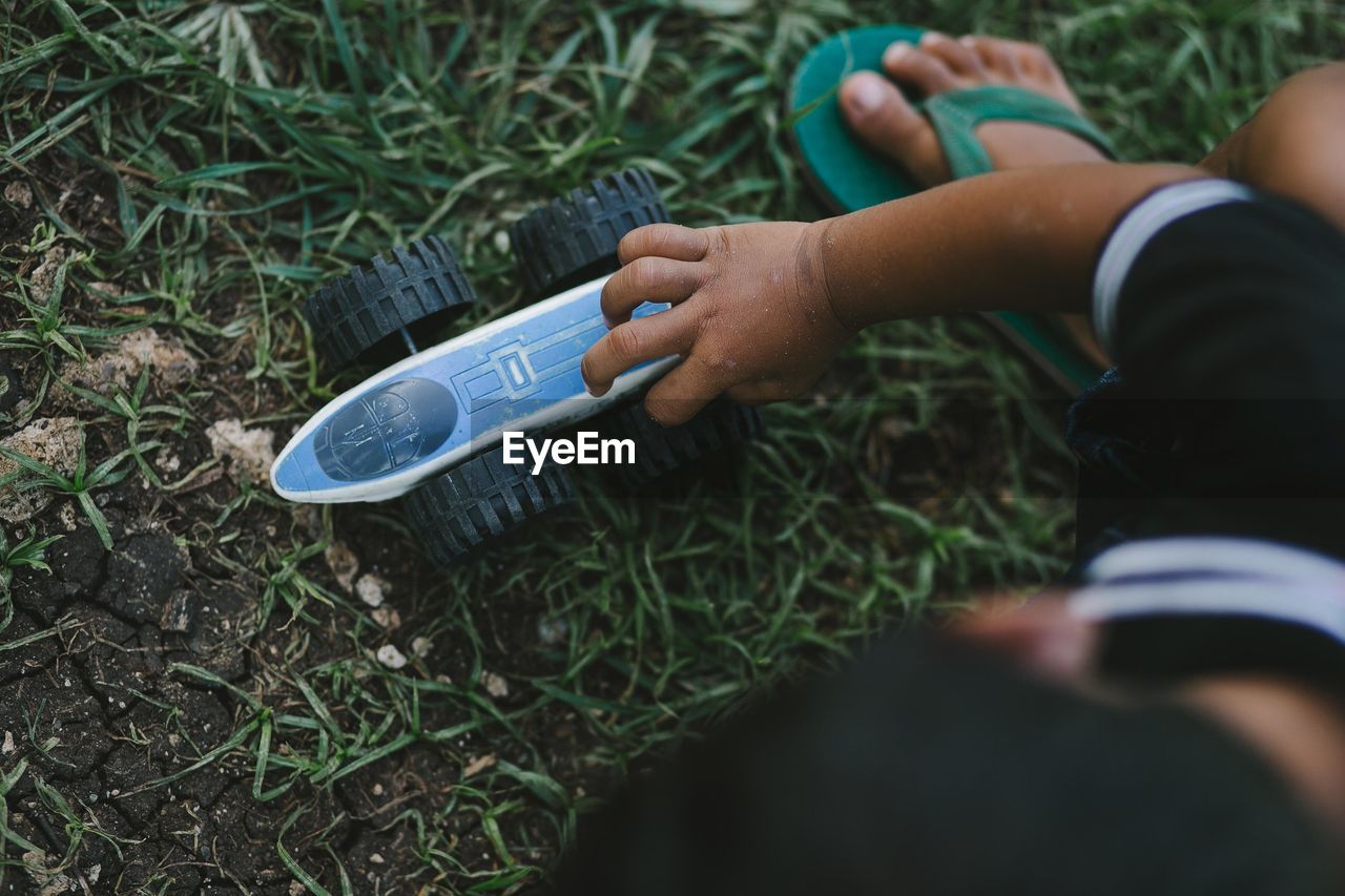 High angle view of baby hand on field