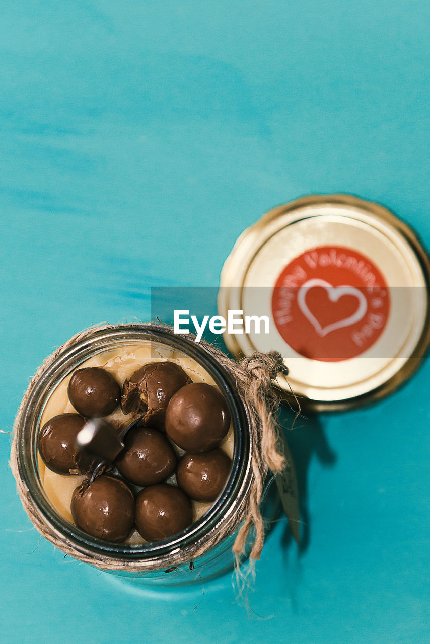 High angle view of sweet caramel and chocolate balls in a glass jar on table