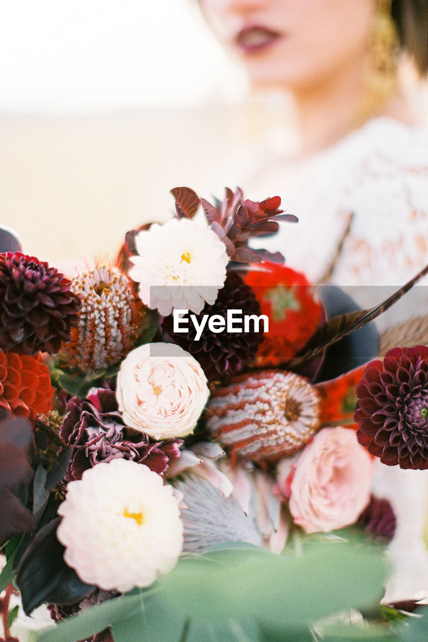 midsection of woman holding flowers