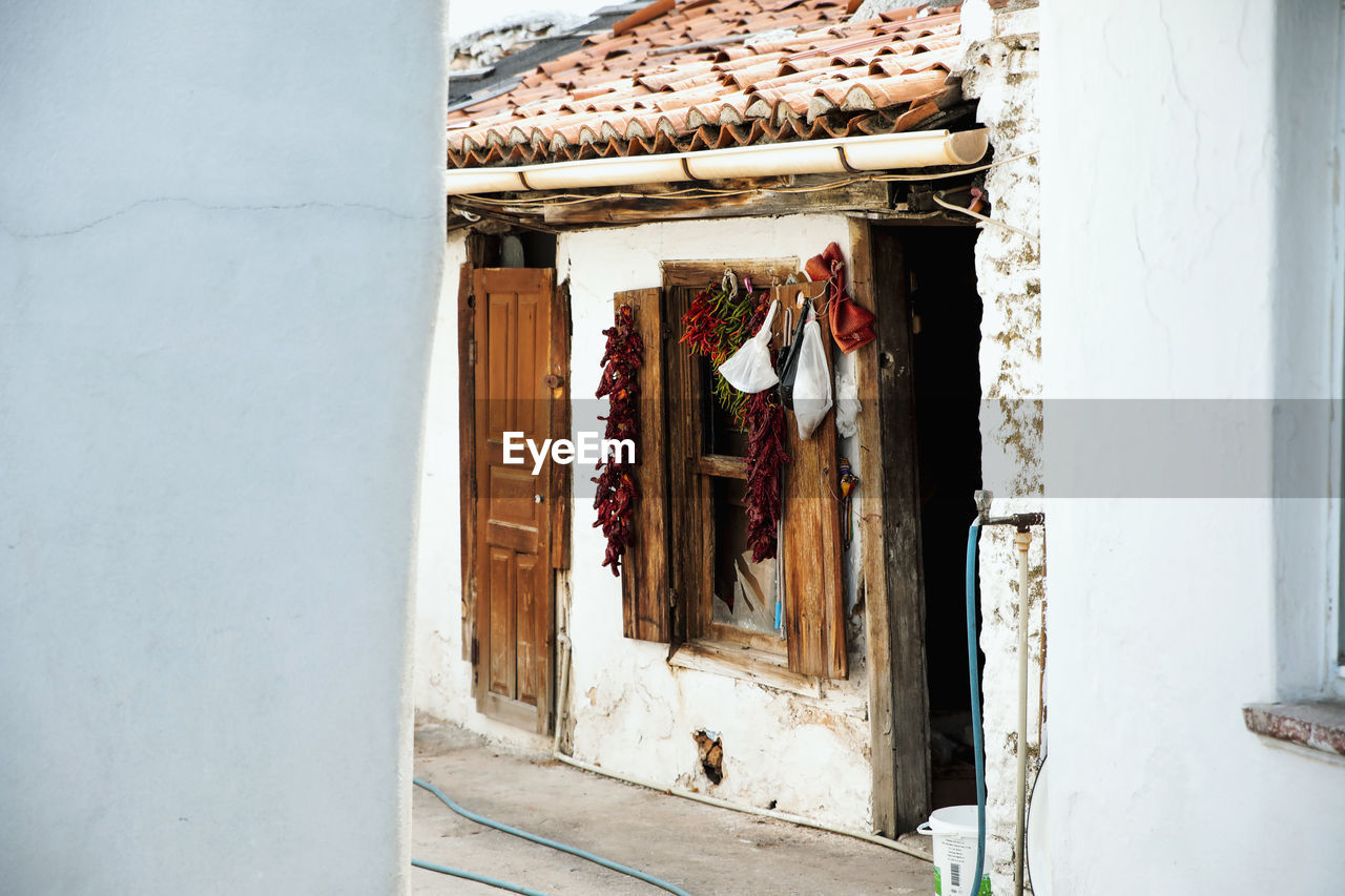 Chilies hanging on window of old house