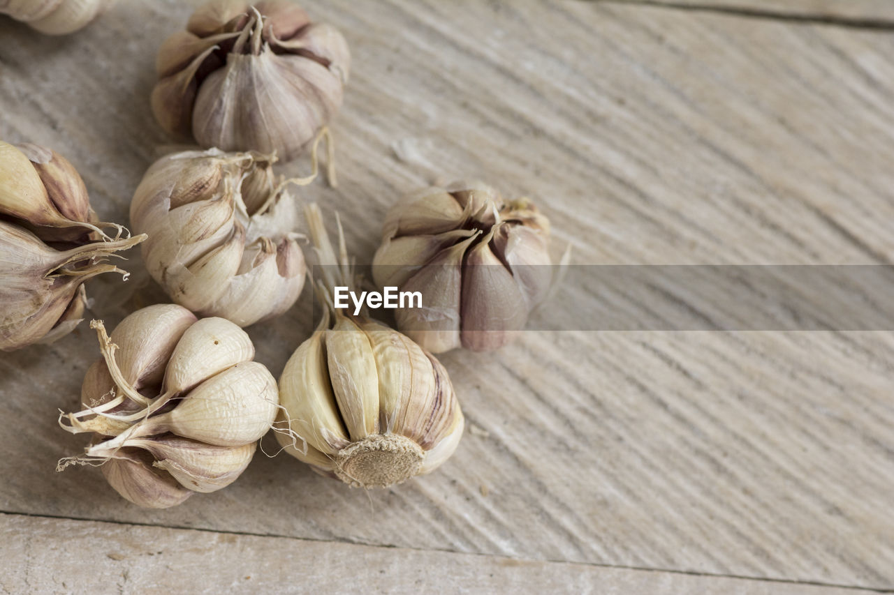 Garlic cloves on a vintage wooden board background, organic and healthy food