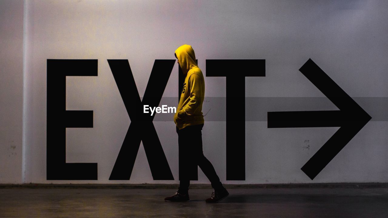 Man walking by exit text