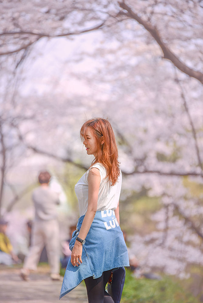 WOMAN STANDING ON TREE TRUNK