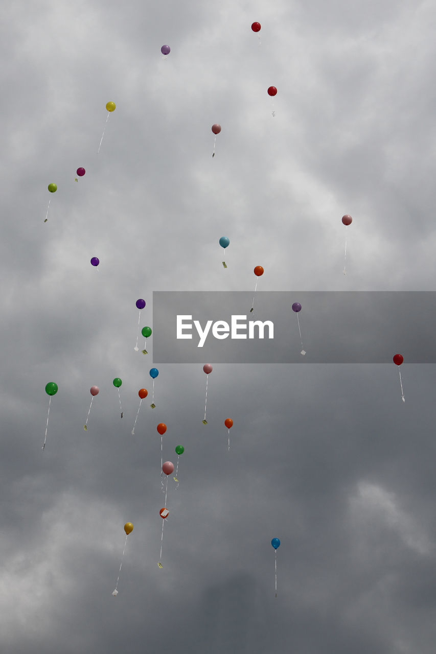 Low angle view of balloons flying against sky