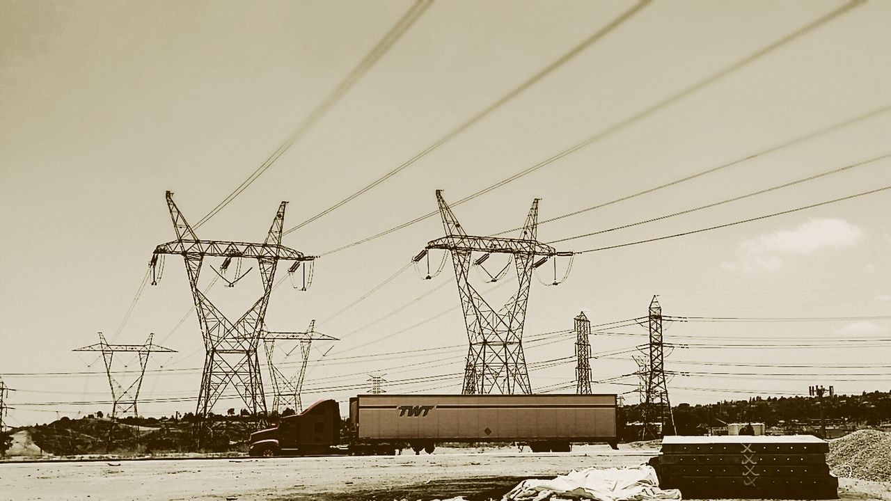 Low angle view of electricity pylons against the sky