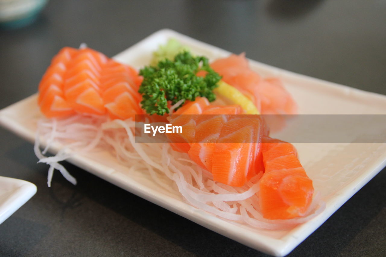 Close-up of salmon sashimi in tray on table