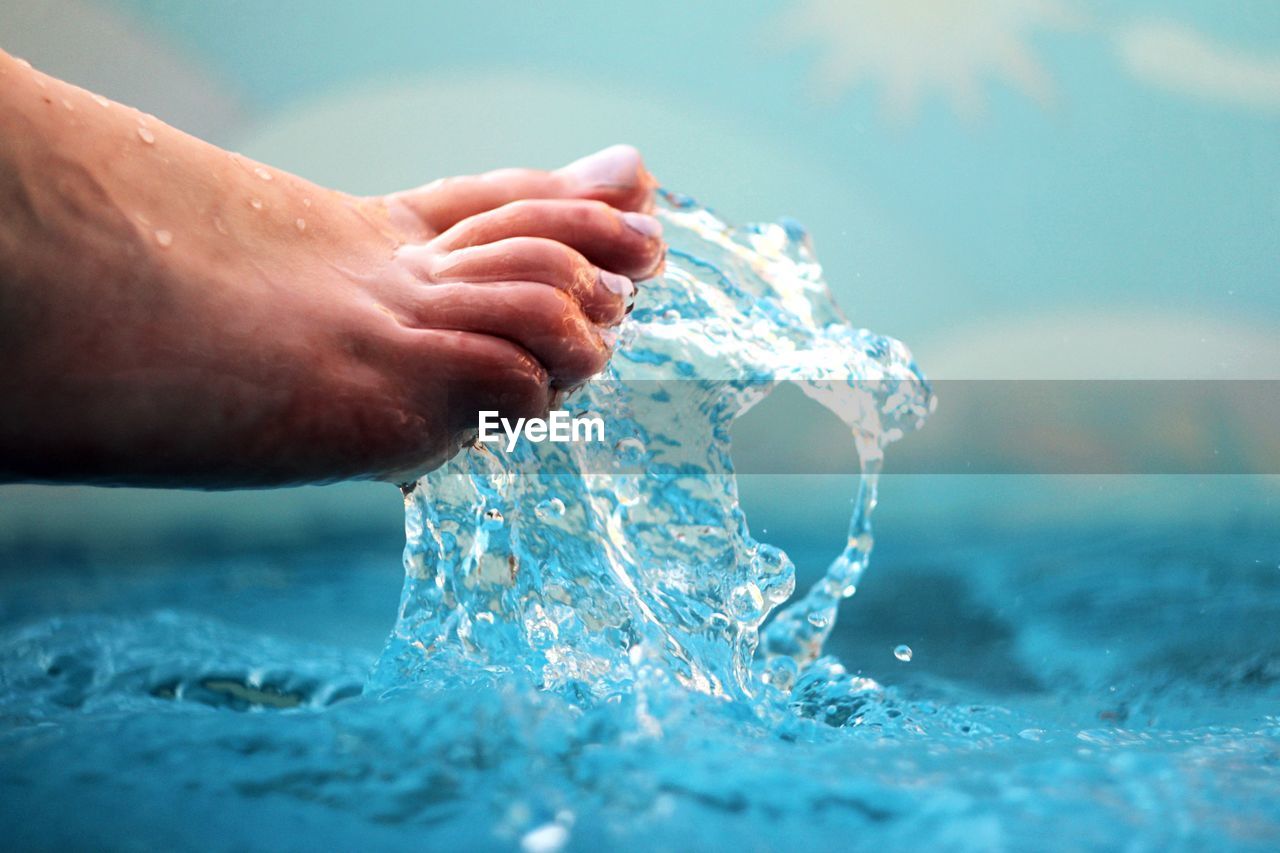 Close-up of feet splashing water