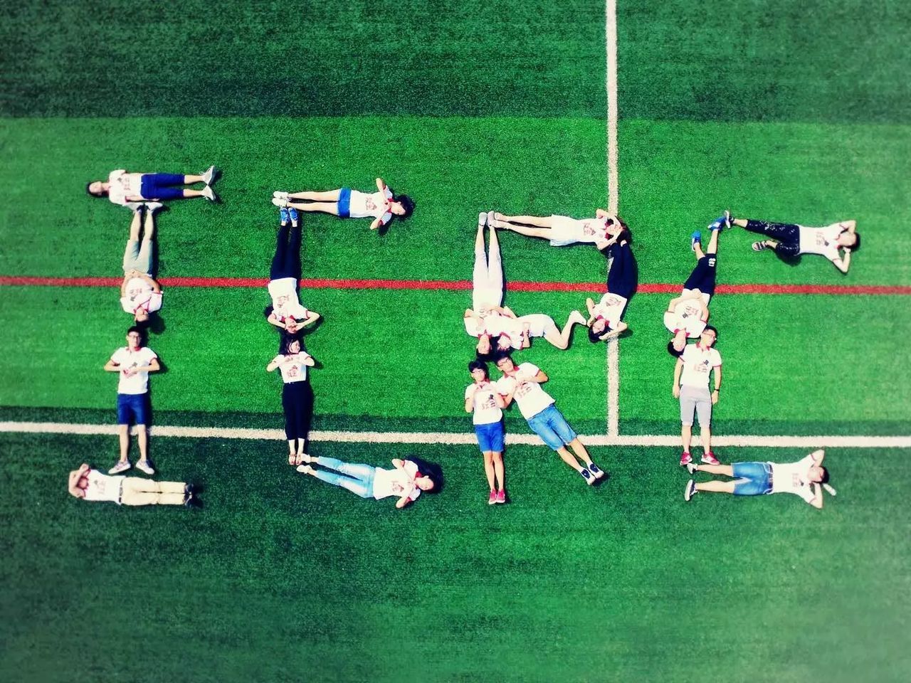 HIGH ANGLE VIEW OF PEOPLE ON GRASS IN STADIUM