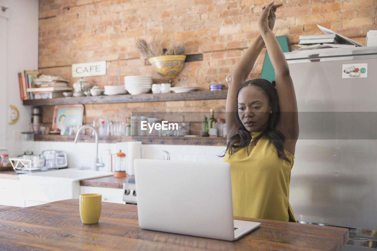 Businesswoman stretching while working at home