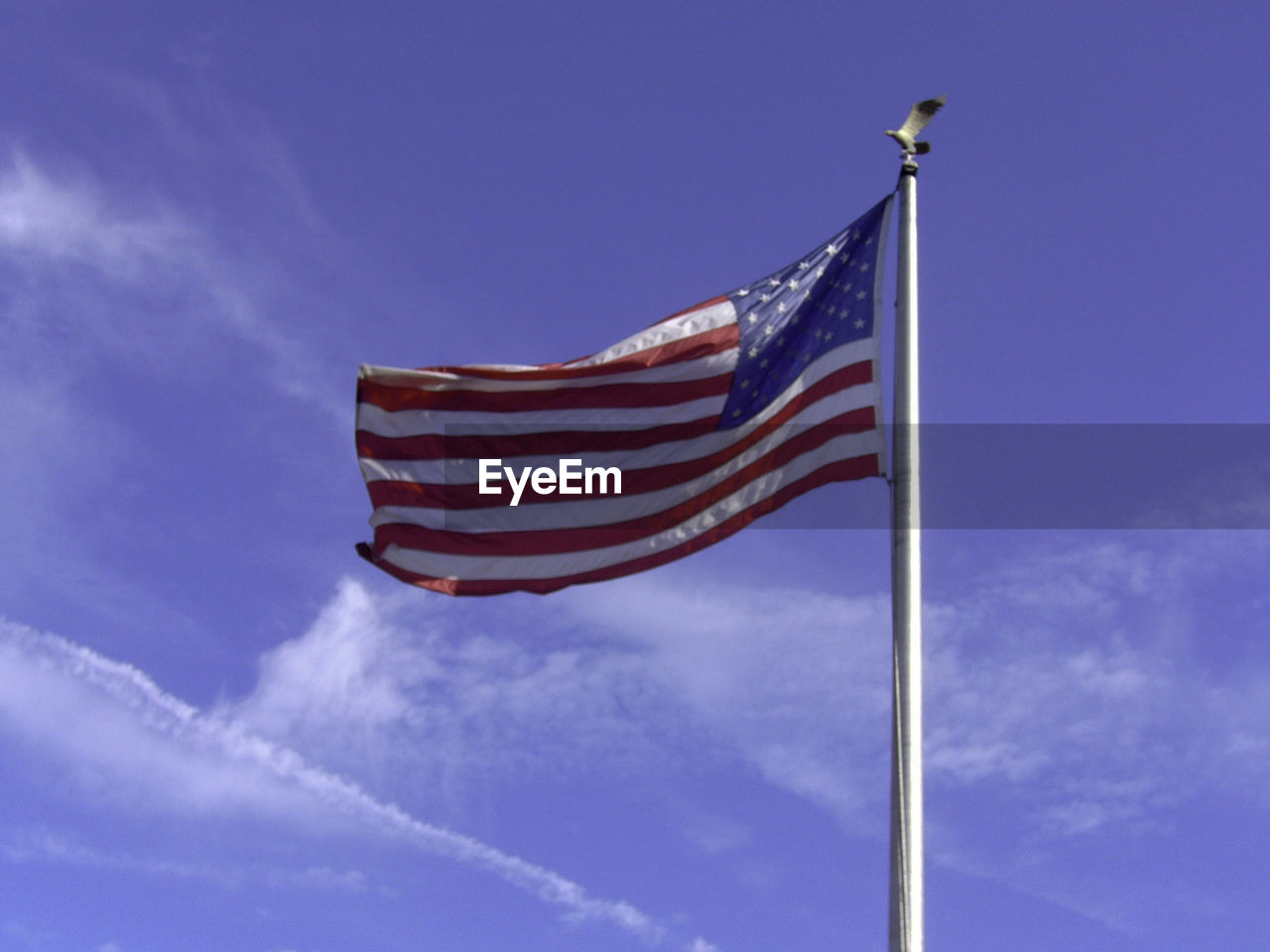 Low angle view of american flag against blue sky