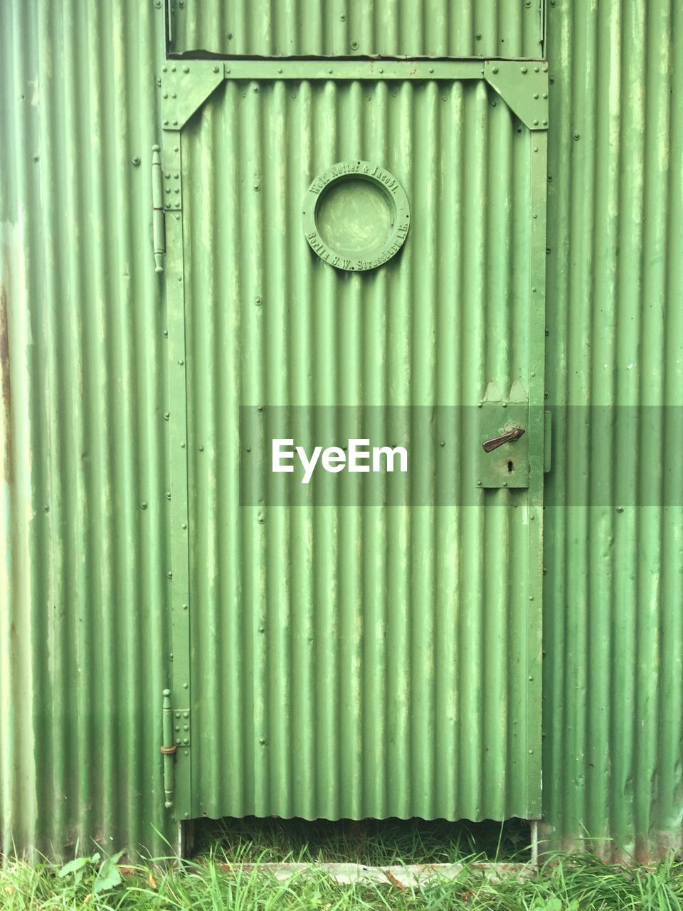 Closed green door of factory