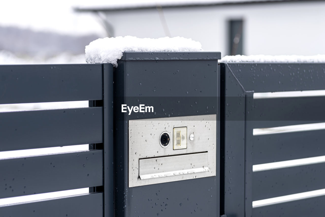 A modern videophone with a letterbox and a wireless card reader, mounted in panel fence 