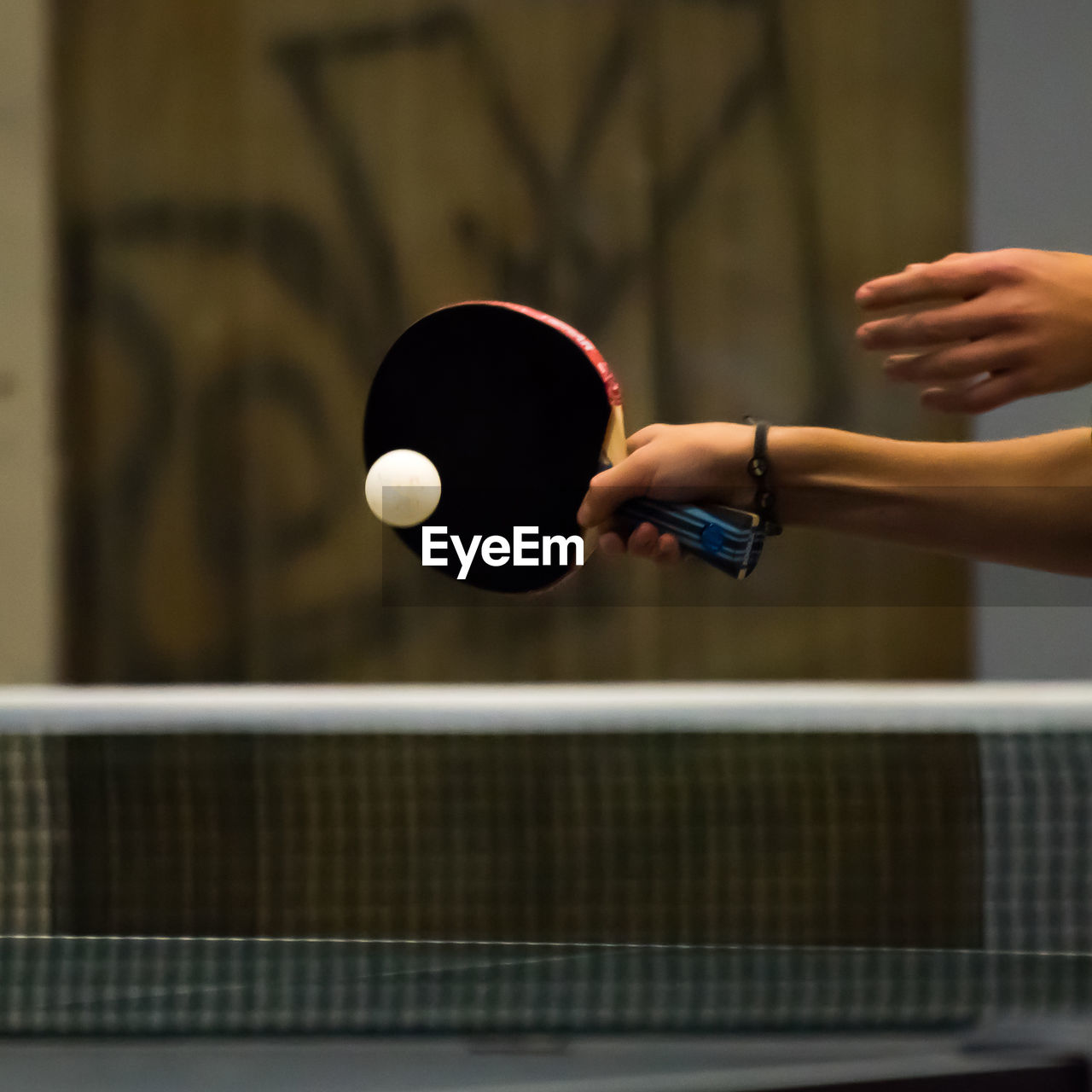 Cropped hand playing table tennis in court