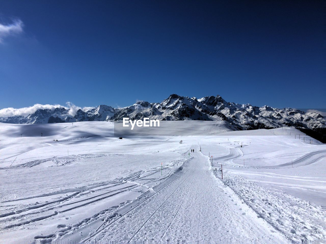 Snow covered landscape with mountains in background