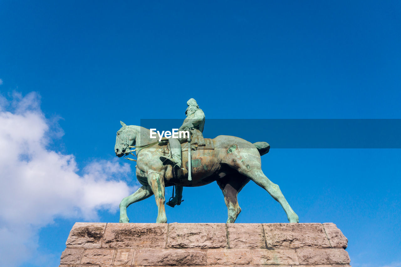 Low angle view of statue against blue sky