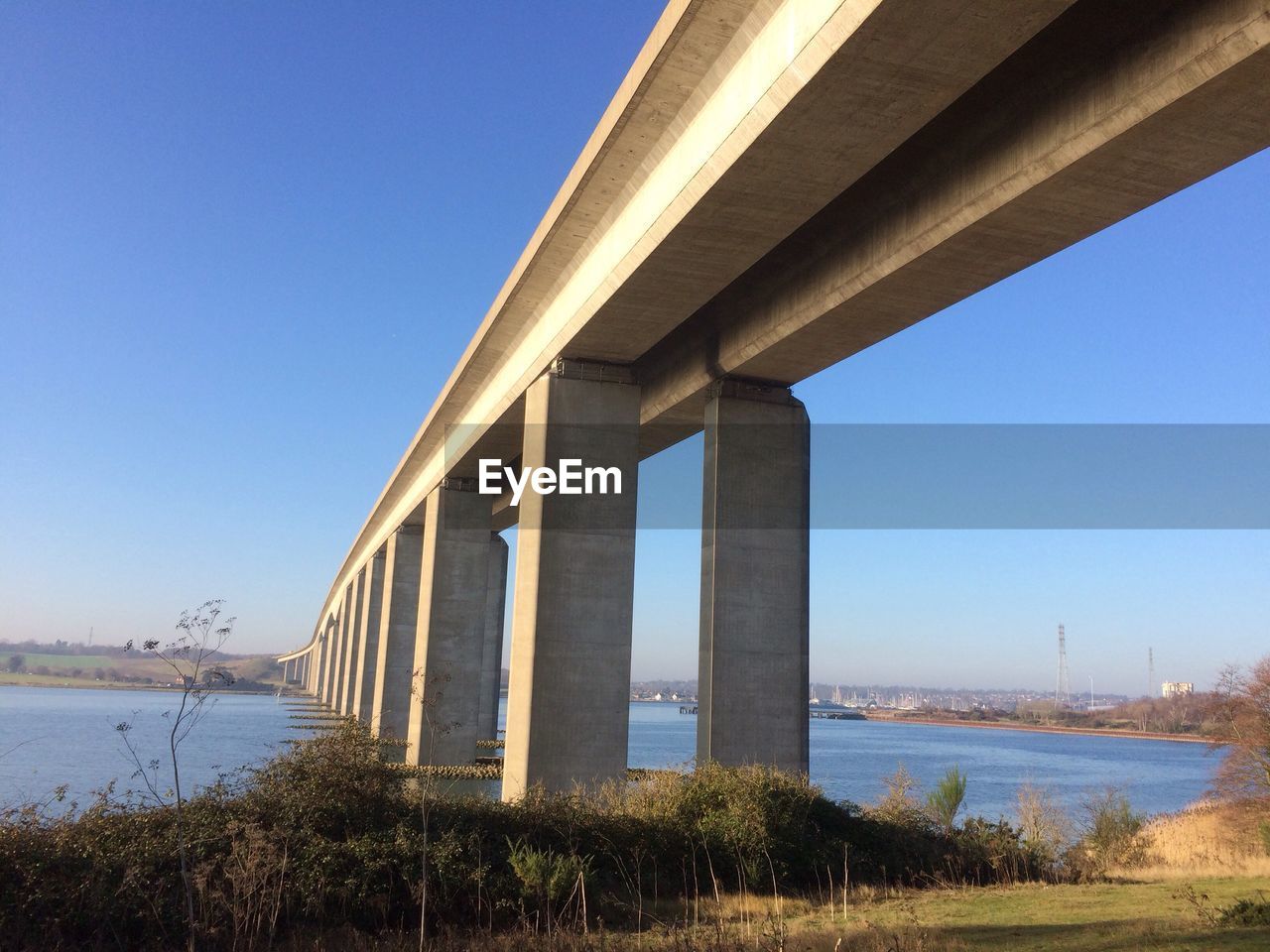 SILHOUETTE BRIDGE OVER RIVER AGAINST CLEAR SKY