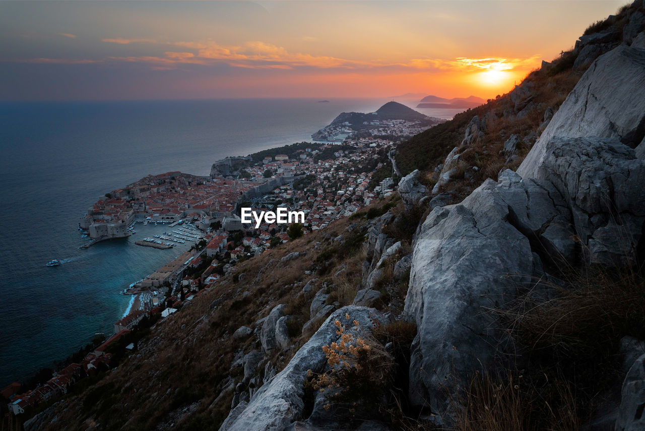 Scenic view of sea and old town dubrovnik against sky during sunset