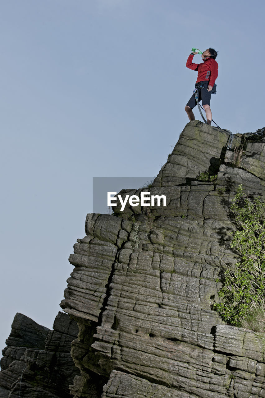 Woman standing on top of windgather rocks in the british peak district
