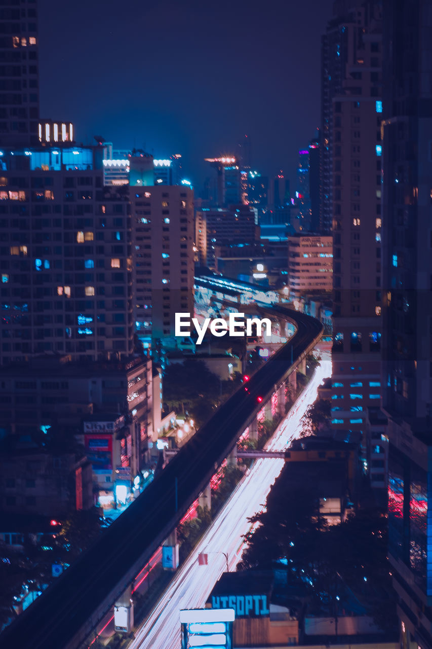 High angle view of illuminated street amidst buildings in city