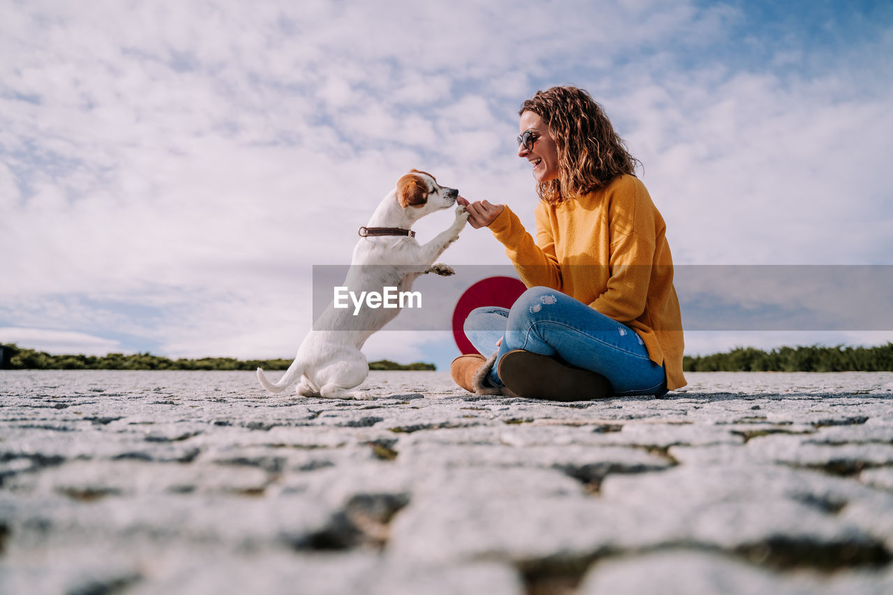 Smiling woman with floor against sky