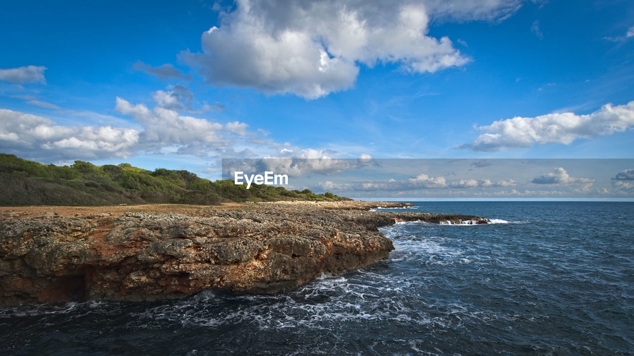 SCENIC VIEW OF ROCKS ON SEA AGAINST SKY