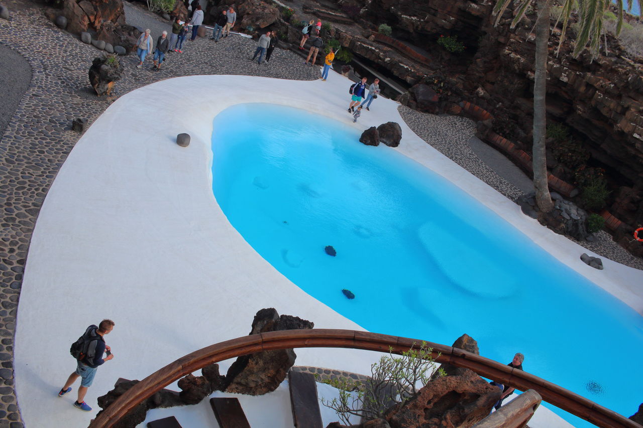 HIGH ANGLE VIEW OF PEOPLE SWIMMING POOL