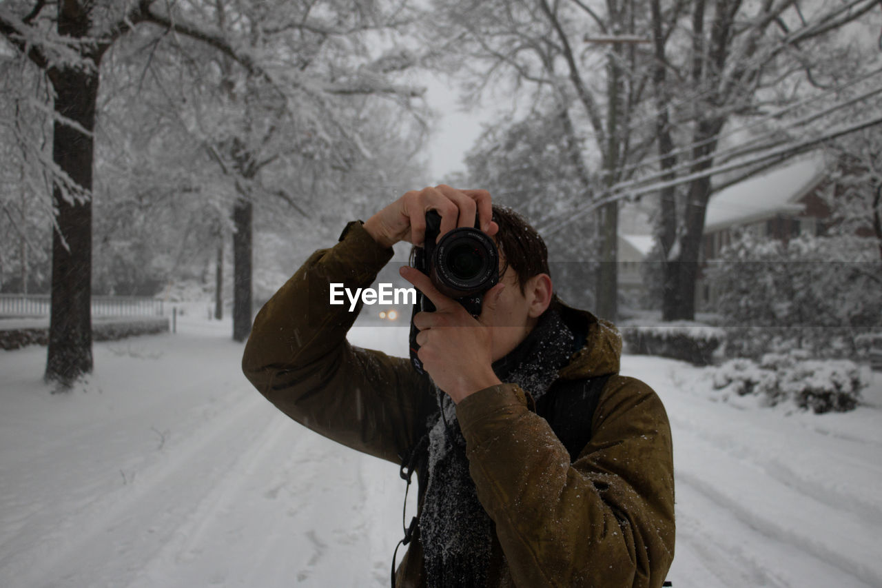 MAN PHOTOGRAPHING WITH SNOW