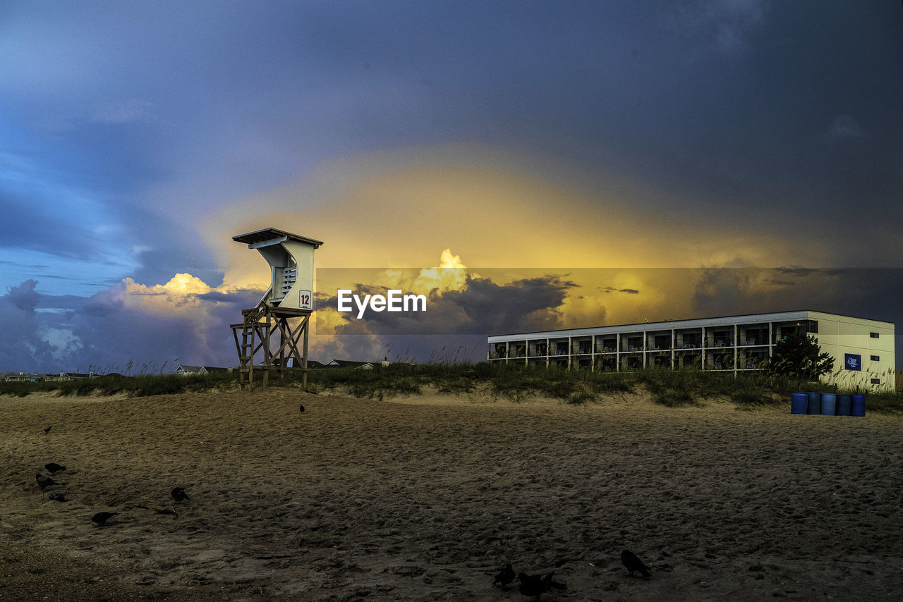 SCENIC VIEW OF BEACH AGAINST SKY AT SUNSET