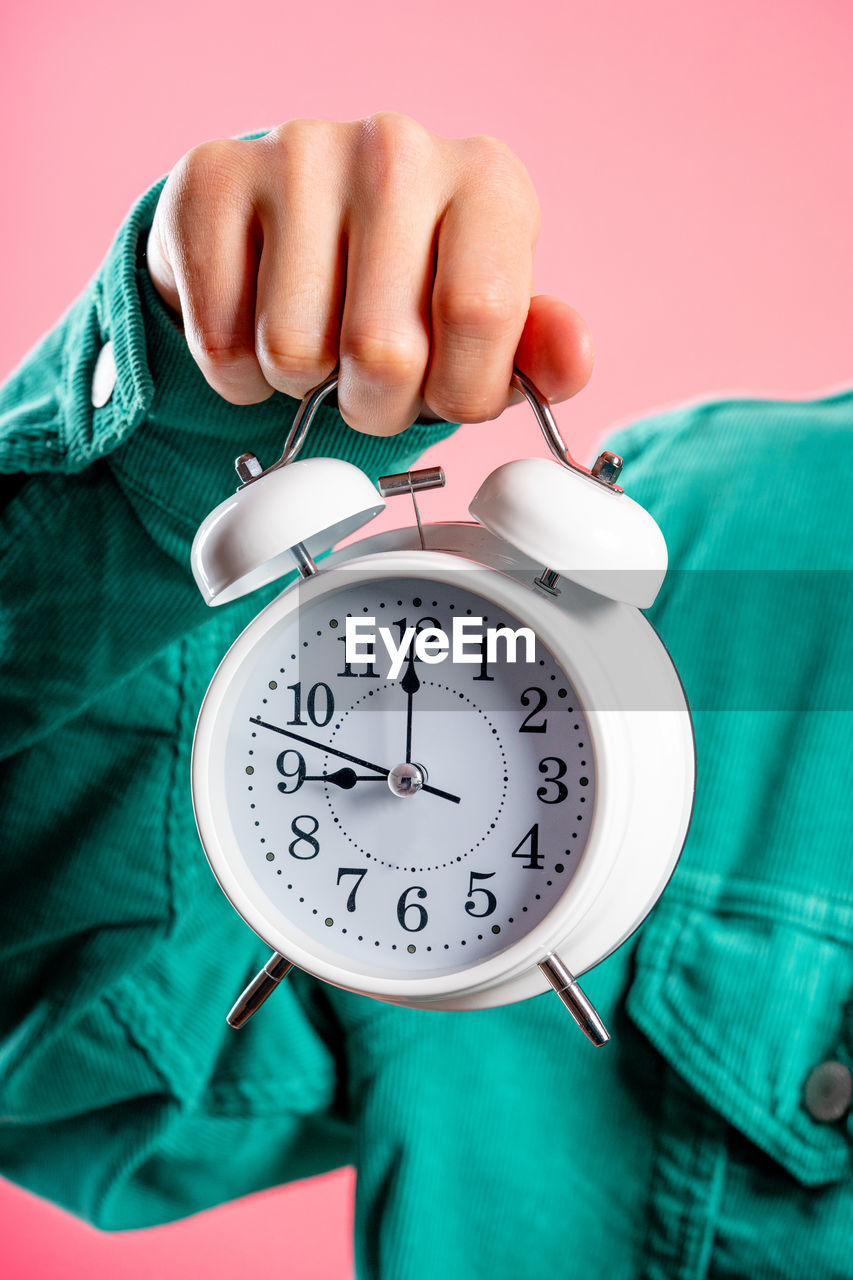 cropped hand of woman holding pocket watch