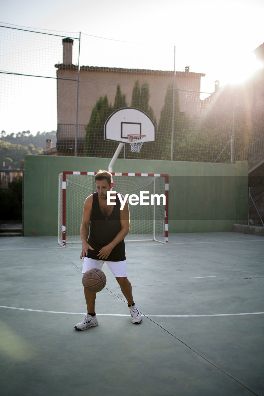 Full length of man playing basketball