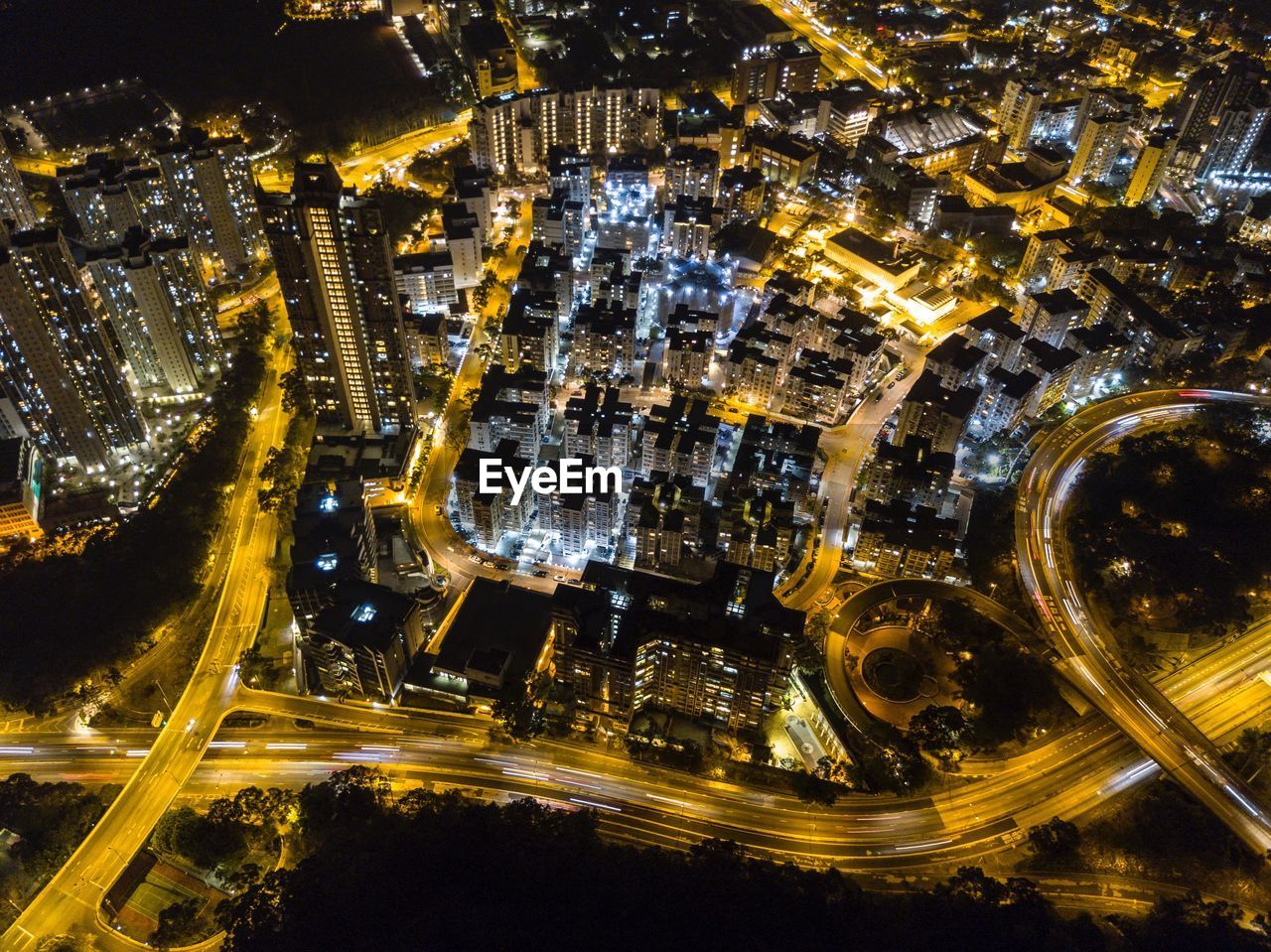 HIGH ANGLE VIEW OF ILLUMINATED CITY BUILDINGS AT NIGHT