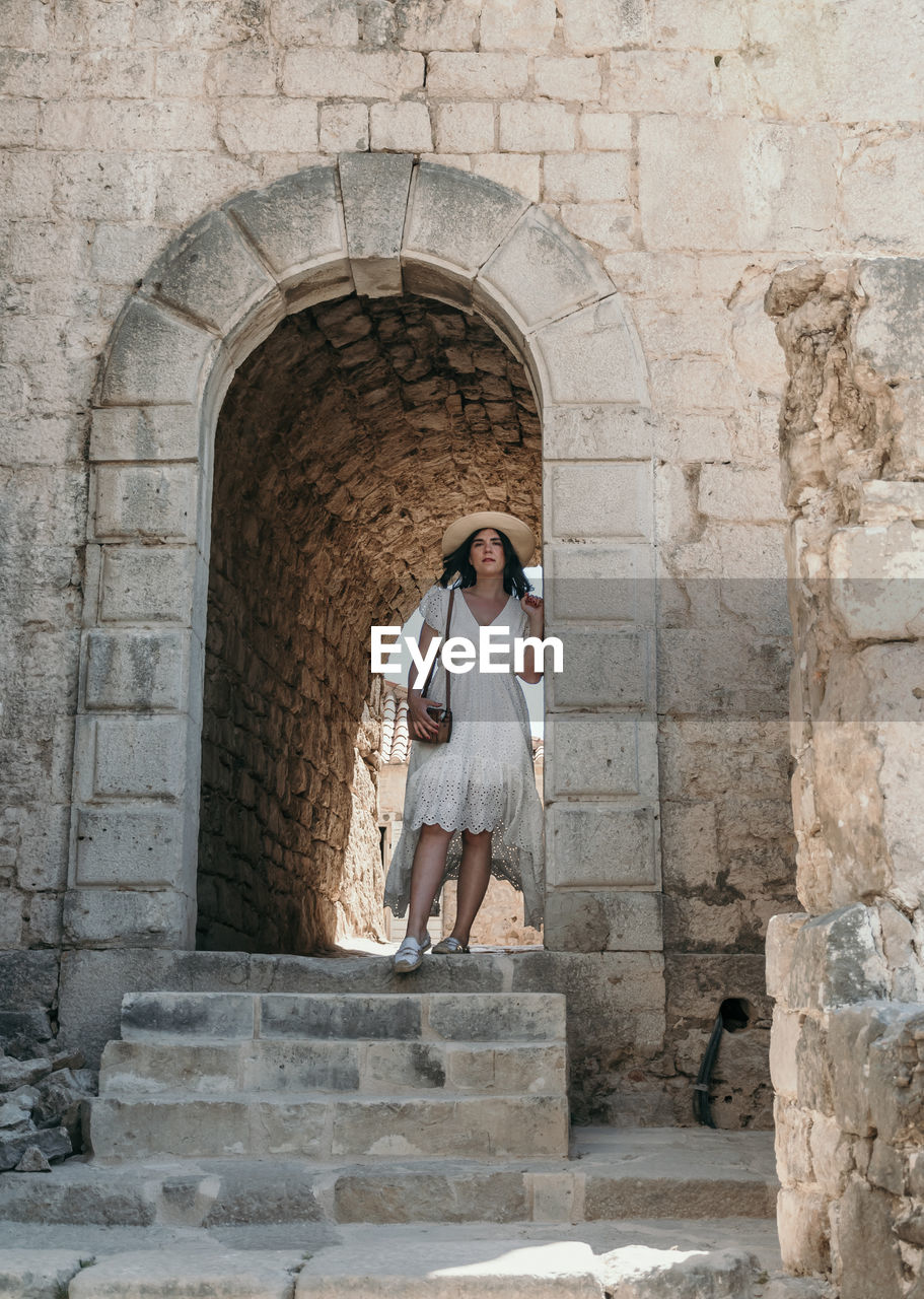 Portrait of woman exploring old medieval settlement inside a fortress of klis near split in croatia.