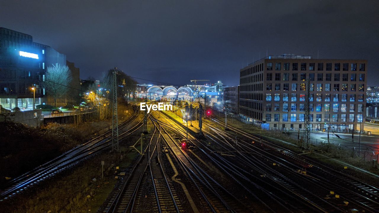 HIGH ANGLE VIEW OF RAILROAD TRACKS AMIDST BUILDINGS IN CITY