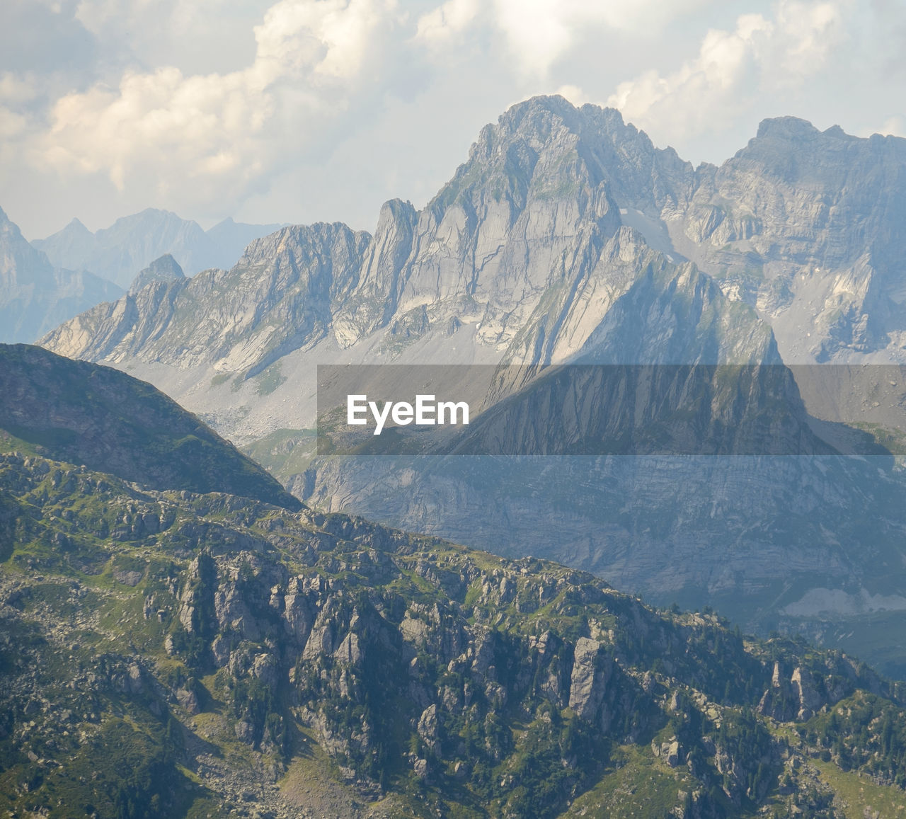 Scenic view of mountains against cloudy sky