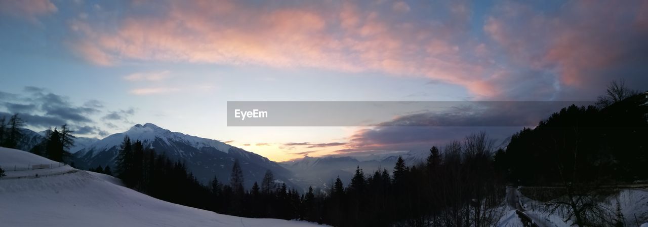 Scenic view of snowcapped mountains against sky during sunset