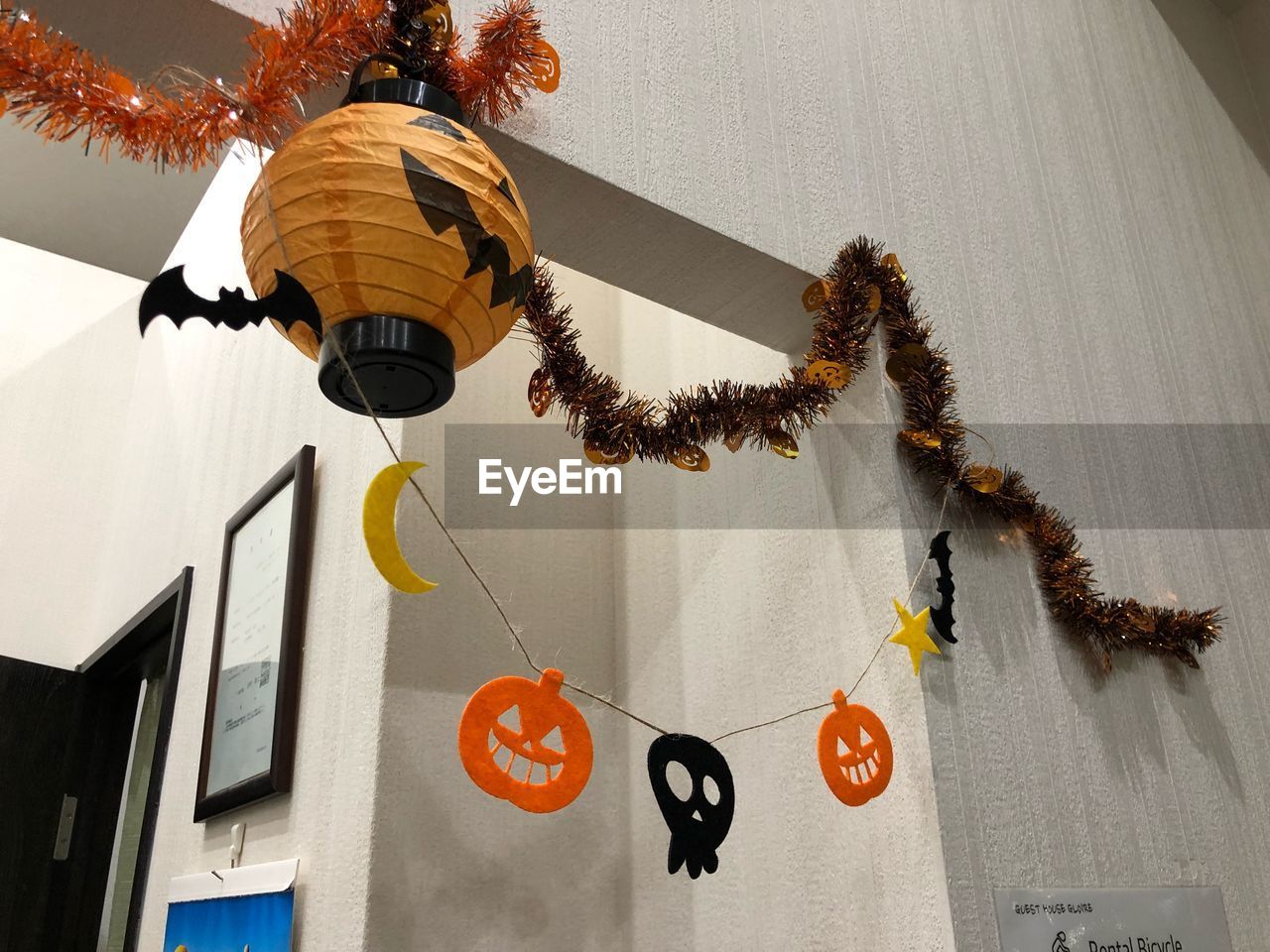LOW ANGLE VIEW OF DECORATIONS HANGING ON WALL BY BUILDING