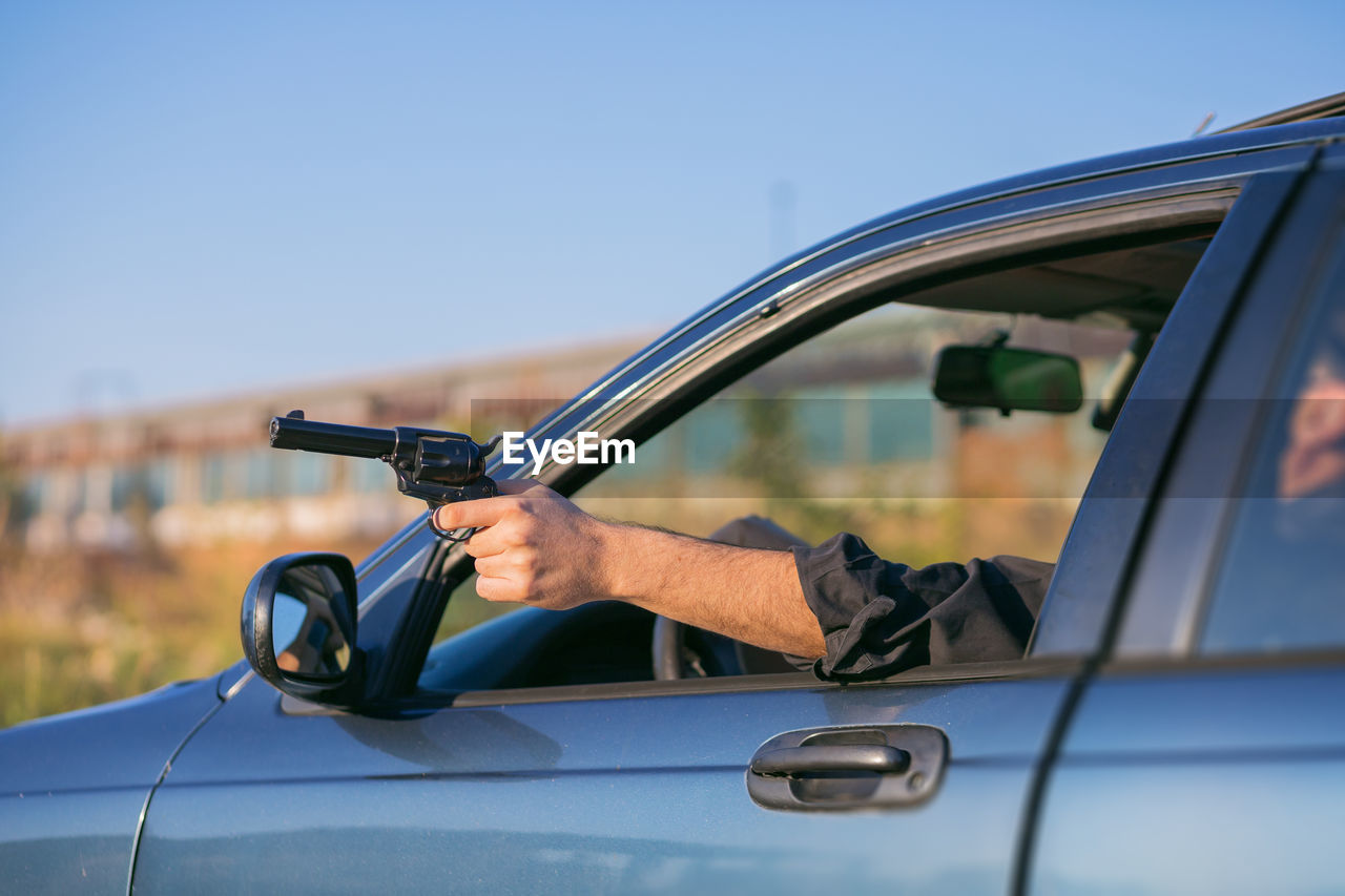 MAN HOLDING GLASS OF CAR