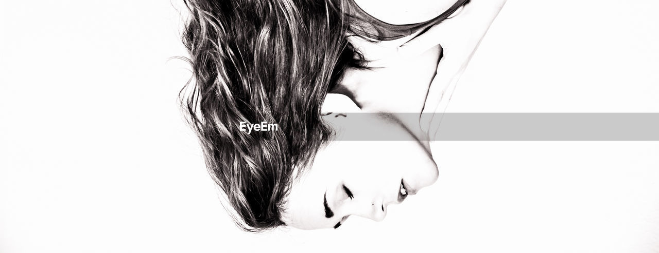 Woman with eyes closed against white background