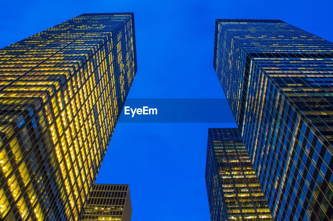 LOW ANGLE VIEW OF ILLUMINATED BUILDINGS AGAINST CLEAR SKY