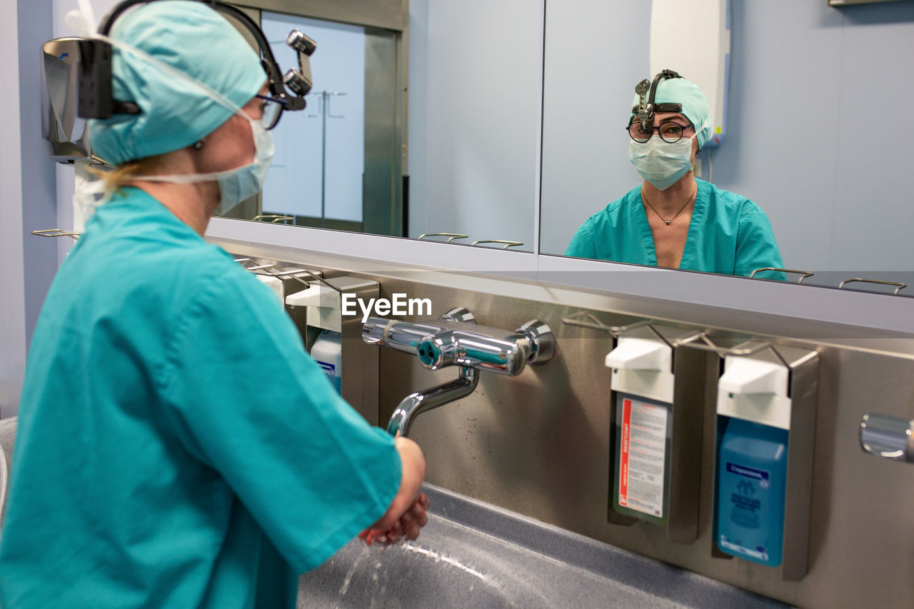 Doctor washing hands over sink