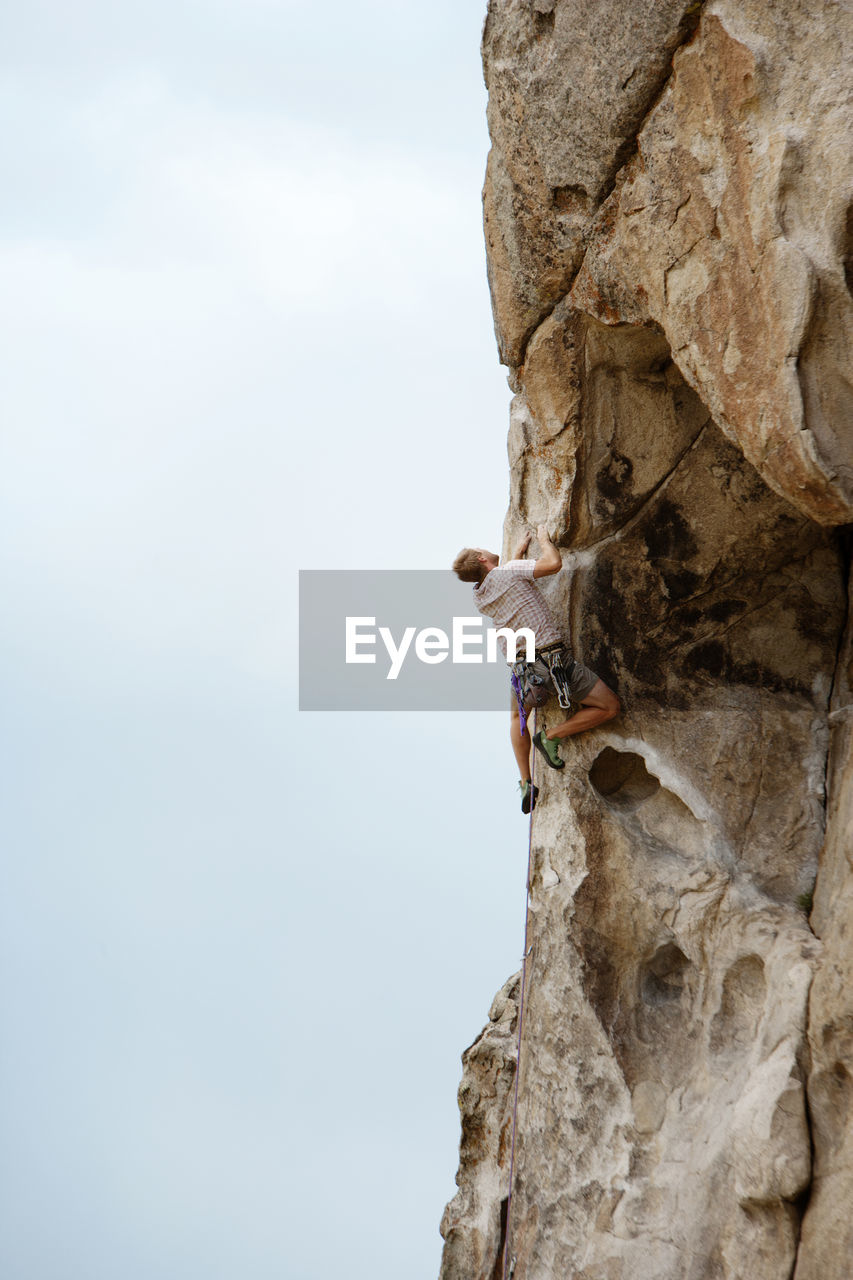 Low angle view of man climbing mountain