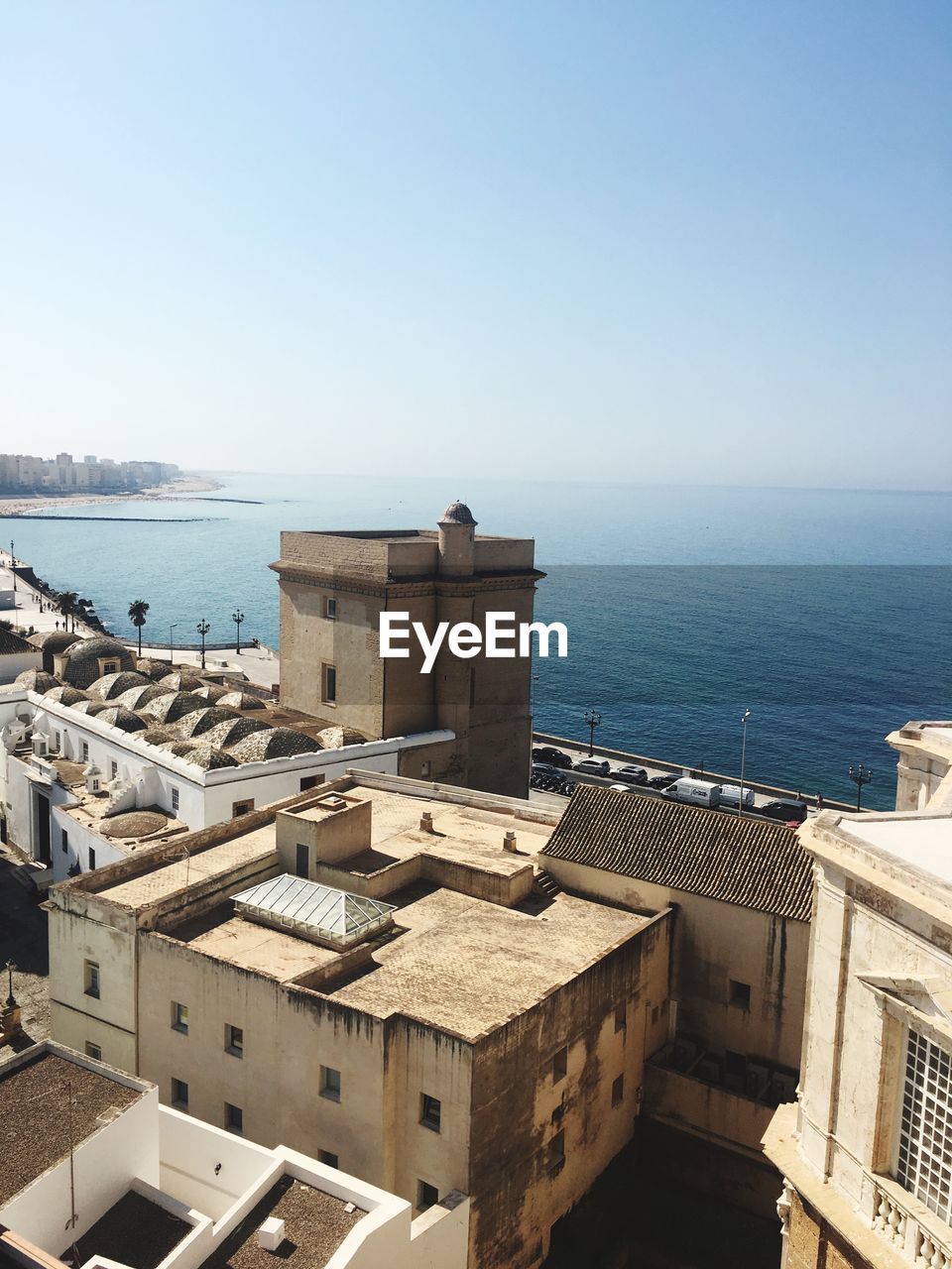 High angle view of buildings by sea against clear sky