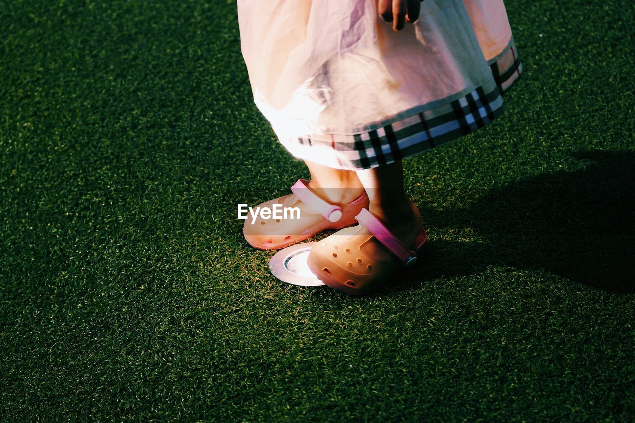 WOMAN STANDING ON GRASS