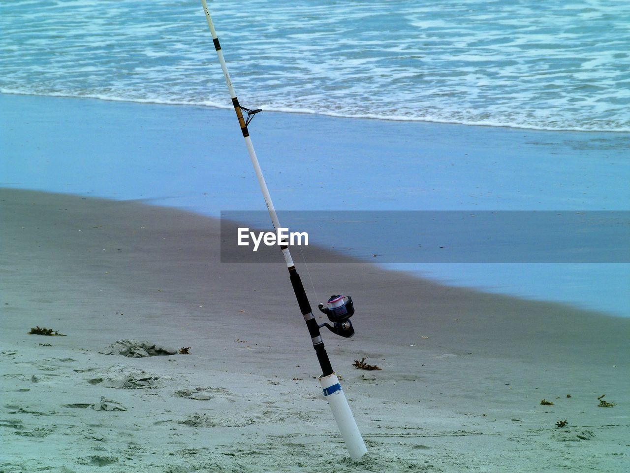 Fishing rod on sand at beach