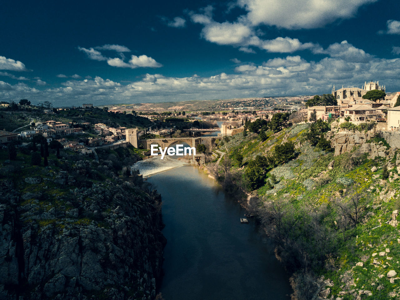 Aerial view of river amidst city against sky