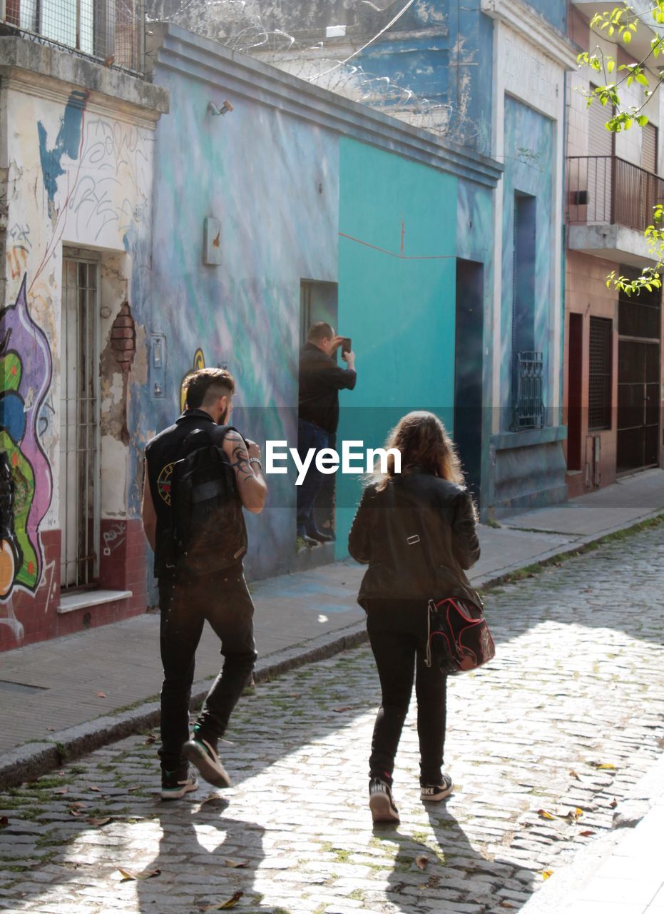 FULL LENGTH REAR VIEW OF WOMEN WALKING ON STREET